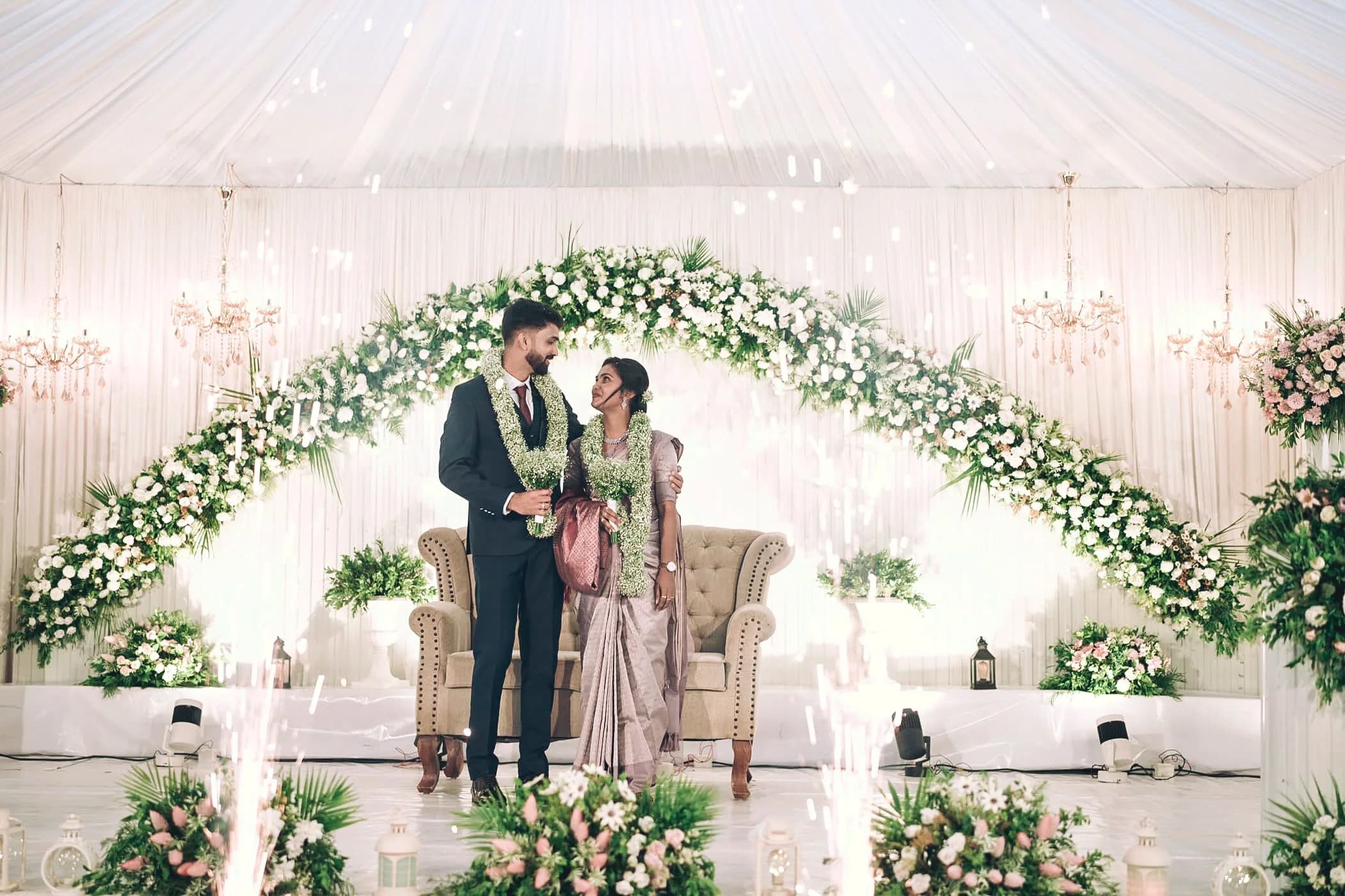 A couple sharing a moment on a floral wedding stage
